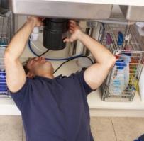 a tech is removing an old garbage disposal